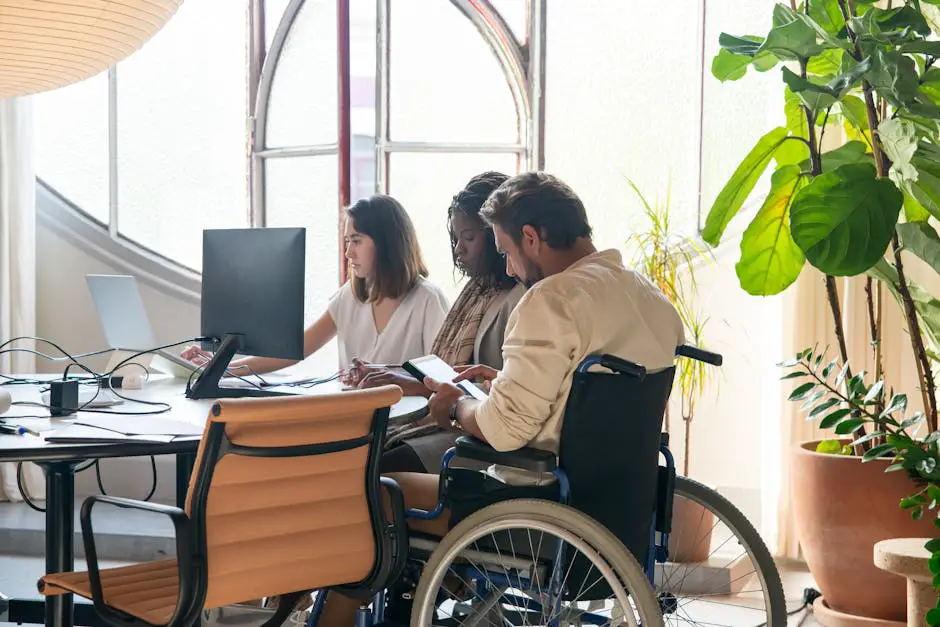 A person using a wheelchair accessing a laptop with visible accessibility features