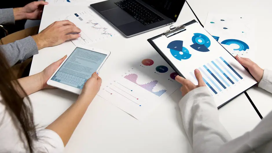 A business team collaborating around a table with web analytics data projected on a screen