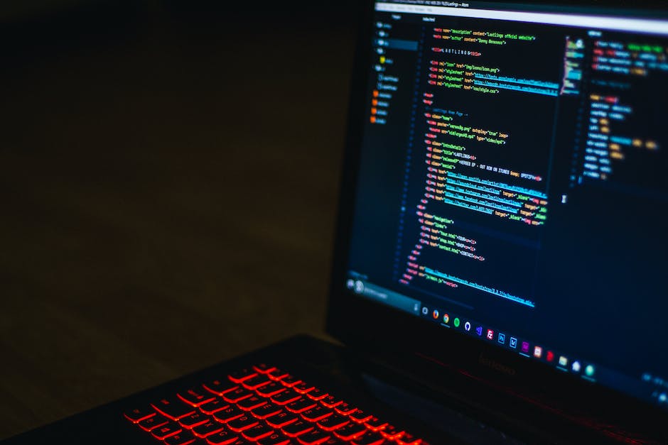 An image of a person typing on a laptop keyboard with HTML, CSS, and JavaScript logos in the background.